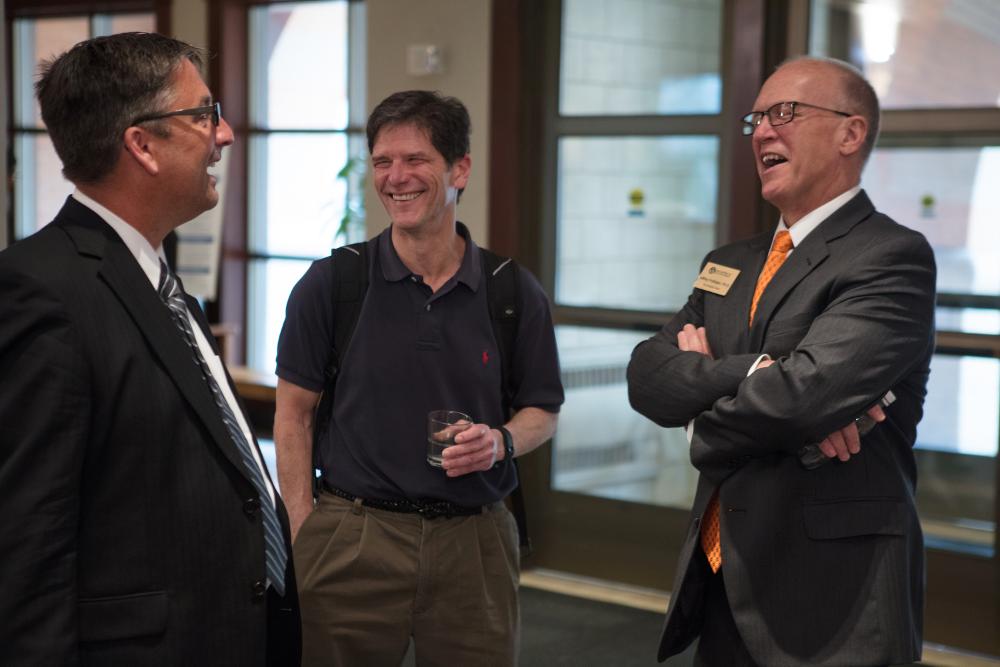 Doctor Potteiger laughing with some guests at the Graduate Showcase